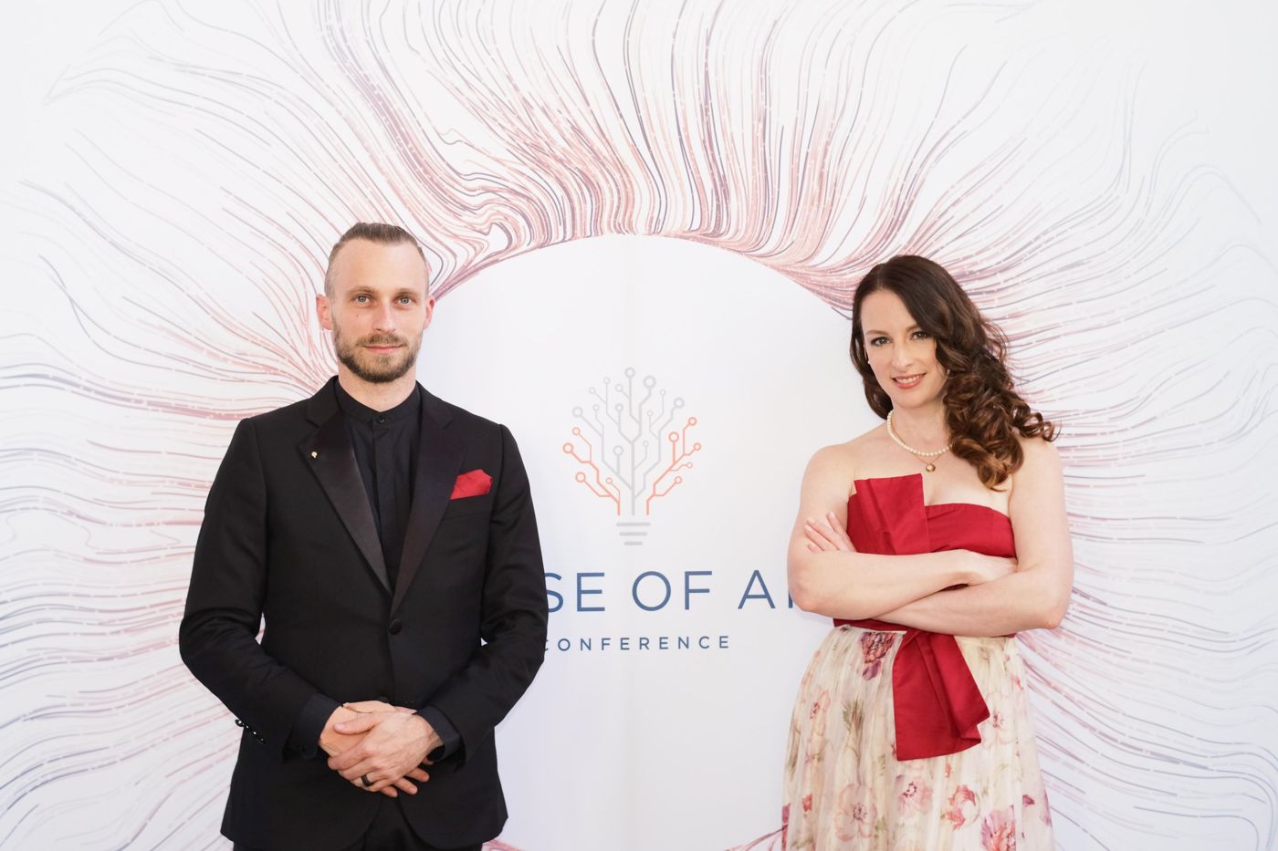 Fabian und Veronika Westerheide als Gastgeber vor der Fotowand der Rise of AI Conference